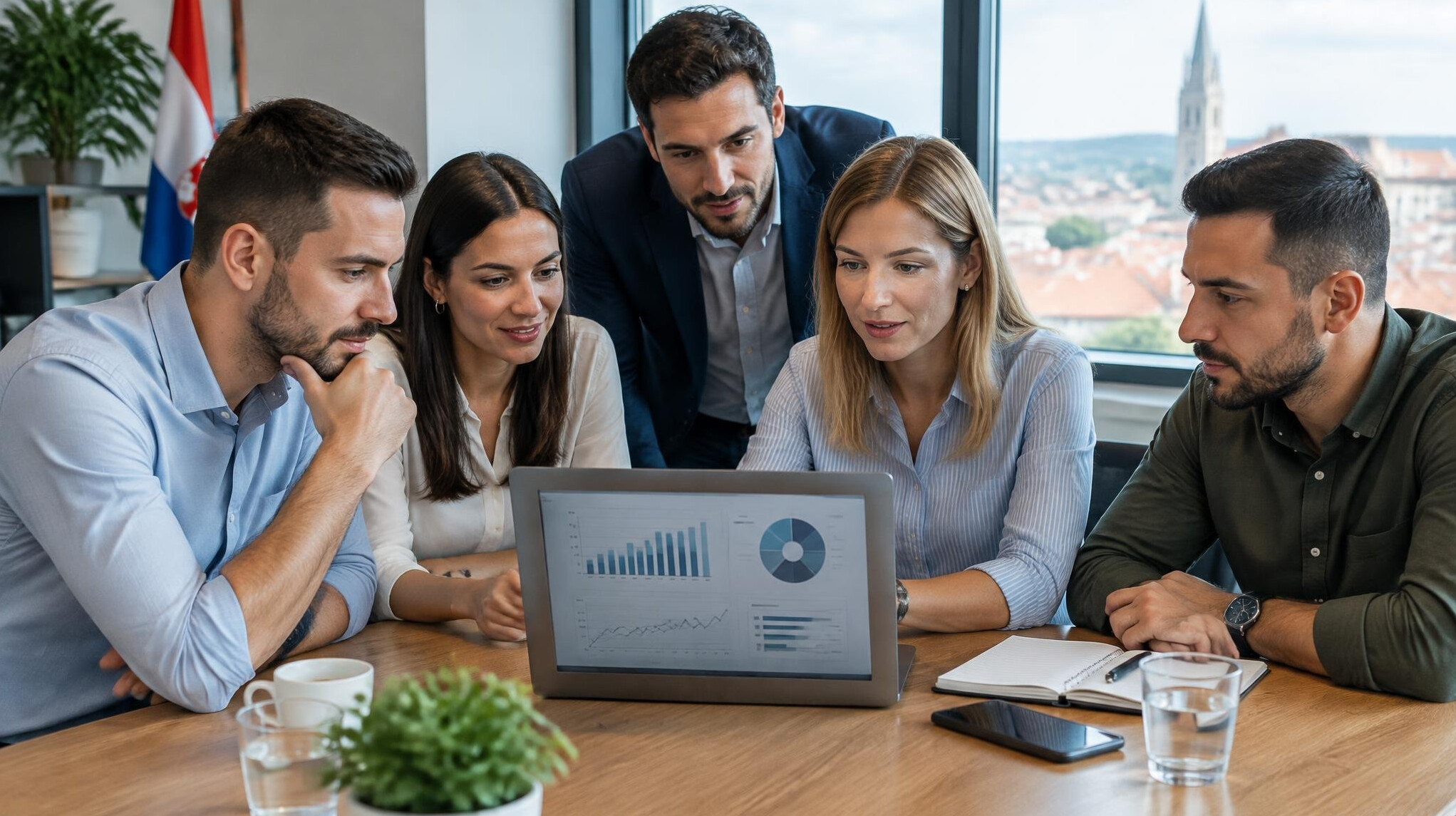 Team of professionals discussing digital risk assessment tools on a laptop